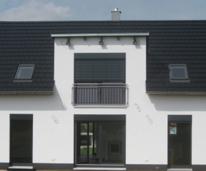 Weißes Einfamilienhaus mit dunklem Dach und dunklen Fensterrahmen