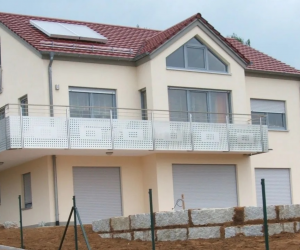 Cremefarbenes Einfamilienhaus mit Kunststoffrolladen mit sehr großen Balkon